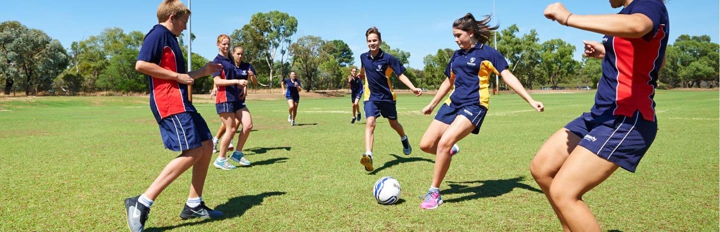Students in custom school sports uniforms playing soccer